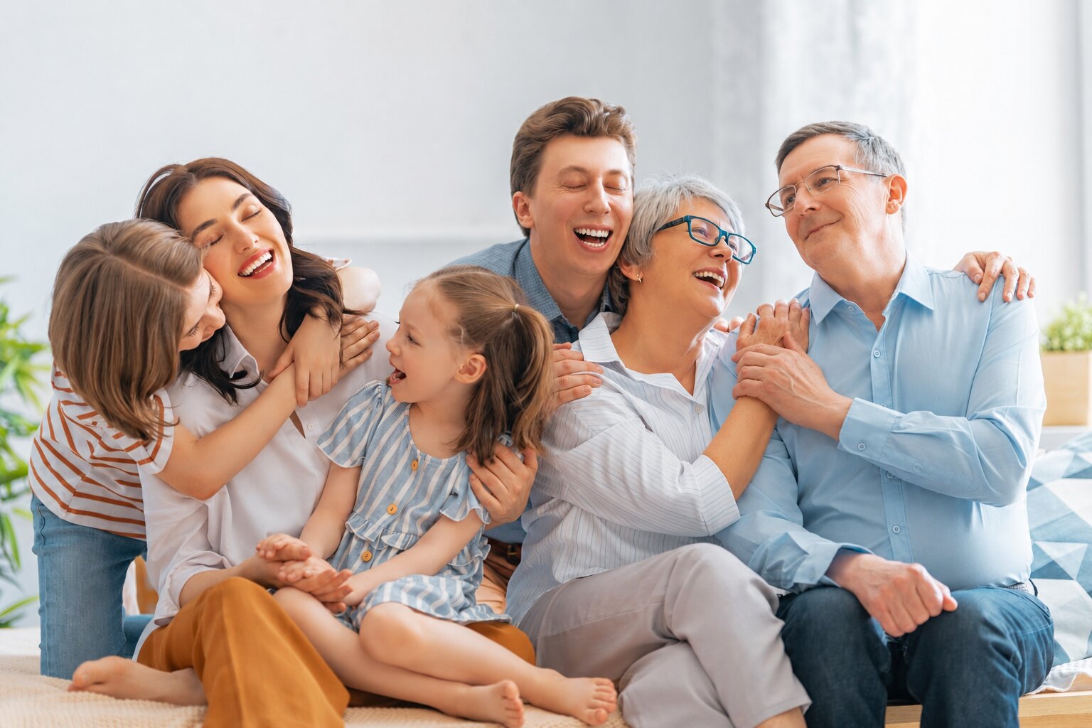 Three generations of one family sitting close together, laughing